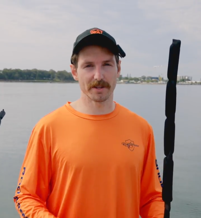 Rod Armour team member by the water, holding a rod in a Rod Armour sleeve